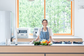 キッチンで料理する若い女性