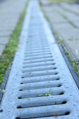 Landscaped urban territory or drain park path with rainwater drainage canal with galvanized wire mesh