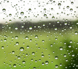 rain water drops on a window glass close up , colored drop macro in a golden light ; gold backdrop textute background