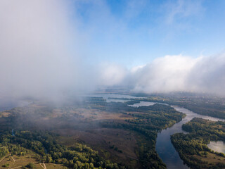 Flight among thick clouds over the Dnieper river in Kiev.