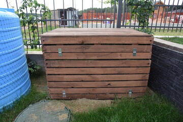 Wooden garden composter after grass cutting or lawn mowing for mulching and reusing like fertilizer
