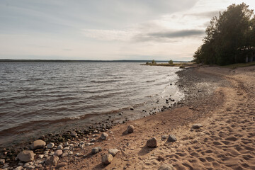 Huge stones on the river bank. Vuoksa river near Imatra in the Leningrad region, Russia. Coastline with birch, pine tree forest reflected in Vuoksa water, near Finland.