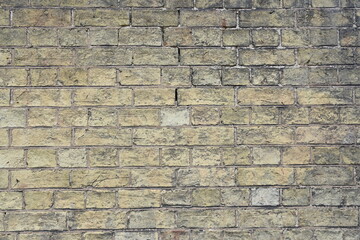 Vintage handmade yellow or biege brick cladding with grey cement texture