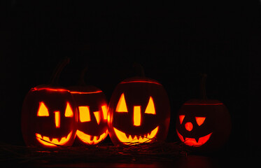 Halloween iluminated pumpkins on wooden background. Halloween background with  copy space.