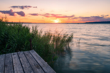 Naklejka na ściany i meble Lake Balaton at sunrise sunset near fonyód with mountain in the background. Tourism in Hungary vacation at the lake in the summer, fishing swimming