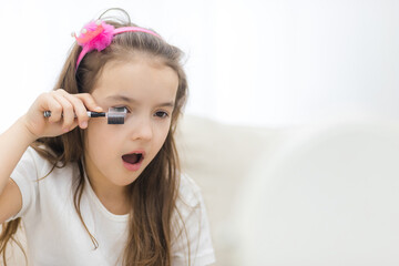 Photo of adorable little girl applying make up.