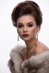 portrait of a beautiful brunette girl with a sophisticated professional visage with full lips and gray-green eyes in furs