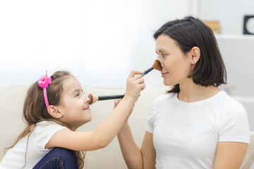 Photo of mother and daughter relationship, doing make up.