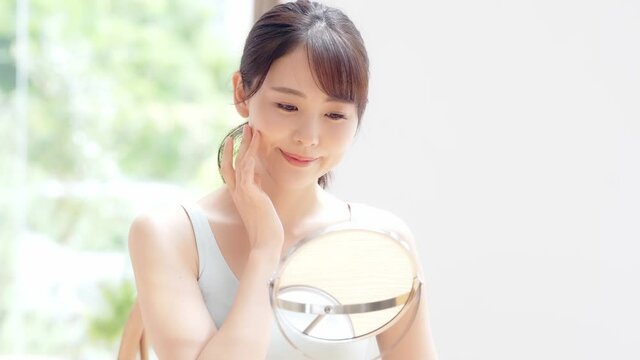 美容イメージ　スキンケア　お肌をチェックする日本人女性