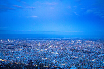View from top of Mt. Moiwa in Sapporo city, Hokkaido, Japan during winter with night cityscape blur...