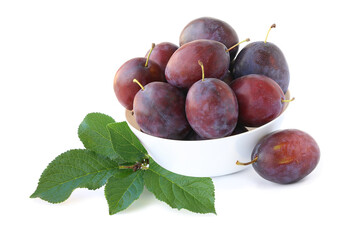 Plums in a bowl with sprig isolated on a white