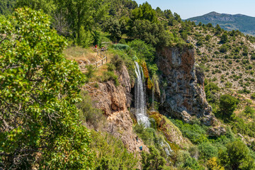 Hiking track over waterfall with tourists in Chera, Spain