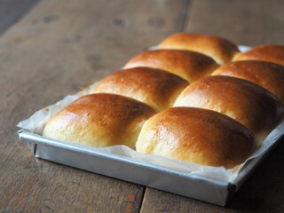 Golden brown baked bread loaf in baking tin