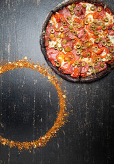 Black dough pizza on a dark stone table. Pizza Nero .