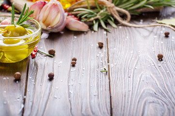 Green olives oils and spices on kitchen table. Cooking concept