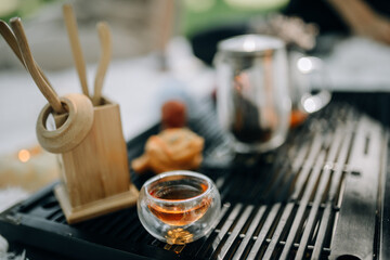 Glass cup for tea ceremony filled with red tea close up