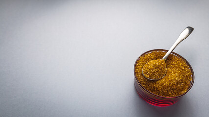 Brown sugar with bowl and spoon on background for text