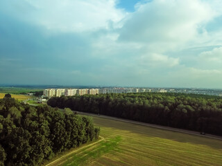 Top view of the city outskirts, fields on a summer day, photo from a drone.
