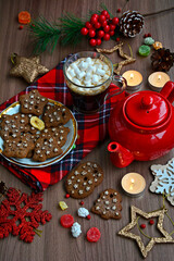 Obraz na płótnie Canvas Mug with coffee and marshmallows, homemade cookies, red teapot, snowflakes, nuts, napkin in a composition of bright winter still life