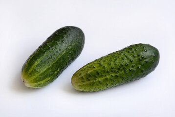 Two ripe cucumbers on a white background.