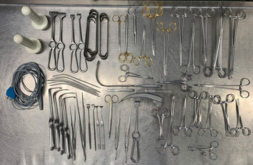 many Surgical instruments lie sorted next to each other on an operating table