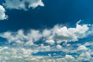 Obraz premium Picturesque white clouds illuminated by sunlight on a blue sky.