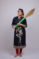 Young asian woman of indian origin with a sweeping broom