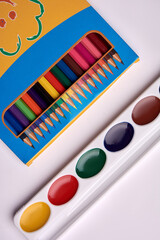 colored pencils watercolor paint palette on a white background