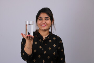 Indian lady/women holding plain glass of water, isolated over white background