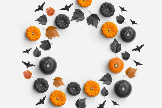 Autumn fall contemporary halloween background composition with pumpkins and leaves in a circle shape.