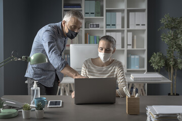 Business people working together in the office and wearing face masks