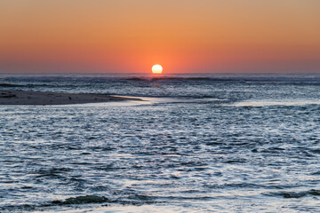 Sun rising over the sea with pelican and seagulls