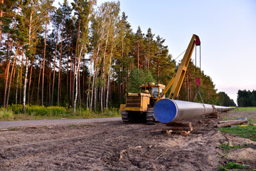 Pipelayer with side boom for Install of  natural gas and crude oil pipes in ground. Construction of the gas pipes. Pipeline construction project  for global exports to international markets.