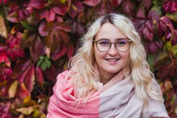 A beautiful blonde girl in a pink coat walks in the Park
