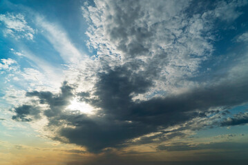 Picturesque white clouds illuminated by sunlight at sunset.