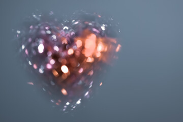 Abstract background: shining crystal heart with bokeh effect on gray-blue background. Heart shaped...