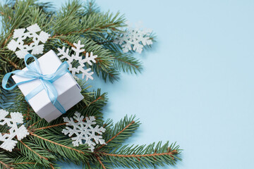 Christmas gift box with blue ribbon and fir branches. copy space