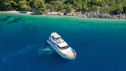 Fototapeta na wymiar Aerial drone photo of luxury yacht anchored in tropical exotic island bay with turquoise sea