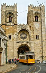 Naklejka na ściany i meble Lisbon Cathedral with the passage of the old tram in Portugal