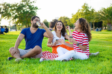 Three friends sitting on the grass in the park