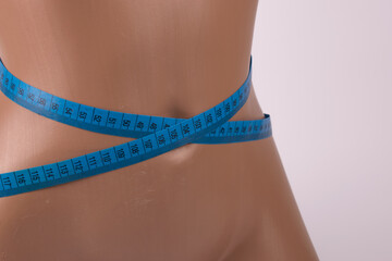 blue centimeter tape on the waist of the mannequin