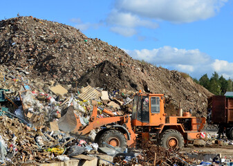 Front-end loader works in a landfill for the disposal of construction waste and other debris. Industrial waste treatment processing factory