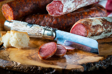 Spanish sausage slices with bread and a folding knife