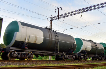 Fototapeta na wymiar Transport tank car LNG by rail, gas - oil products. LPG transport propane. The fuel train, rolling stock with petrochemical tank cars. Liquefied natural gas export. Soft focus, possible granularity