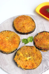 Indian side dish or appetizer  Vangyache Kaap, fried Eggplants, Crispy brinjal fry, Aubergine disks, served with tomato ketchup. With copy space
