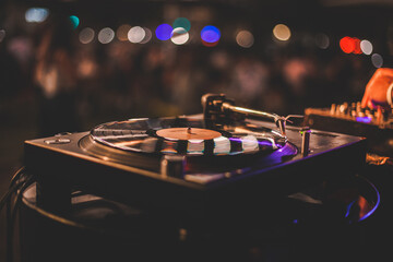 Close up di un piatto da disk jockey durante un evento serale di un locale estivo all'aperto con...