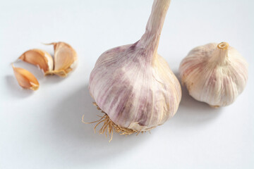Two garlic heads and three cloves isolated on a white background