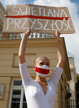 People carrying historical white-red-white flags of Belarus gather in Warsaw