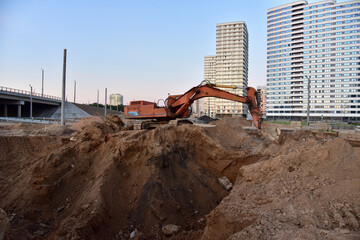 Excavator during excavation at construction site. Backhoe on road work. Heavy Construction...