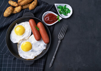 morning breakfast. Fried eggs with sausages in a frying pan.